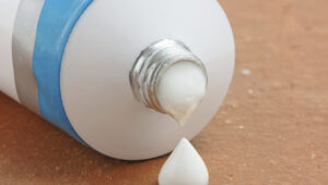 A tube of generic ointment or cream with a droplet squeezed out
